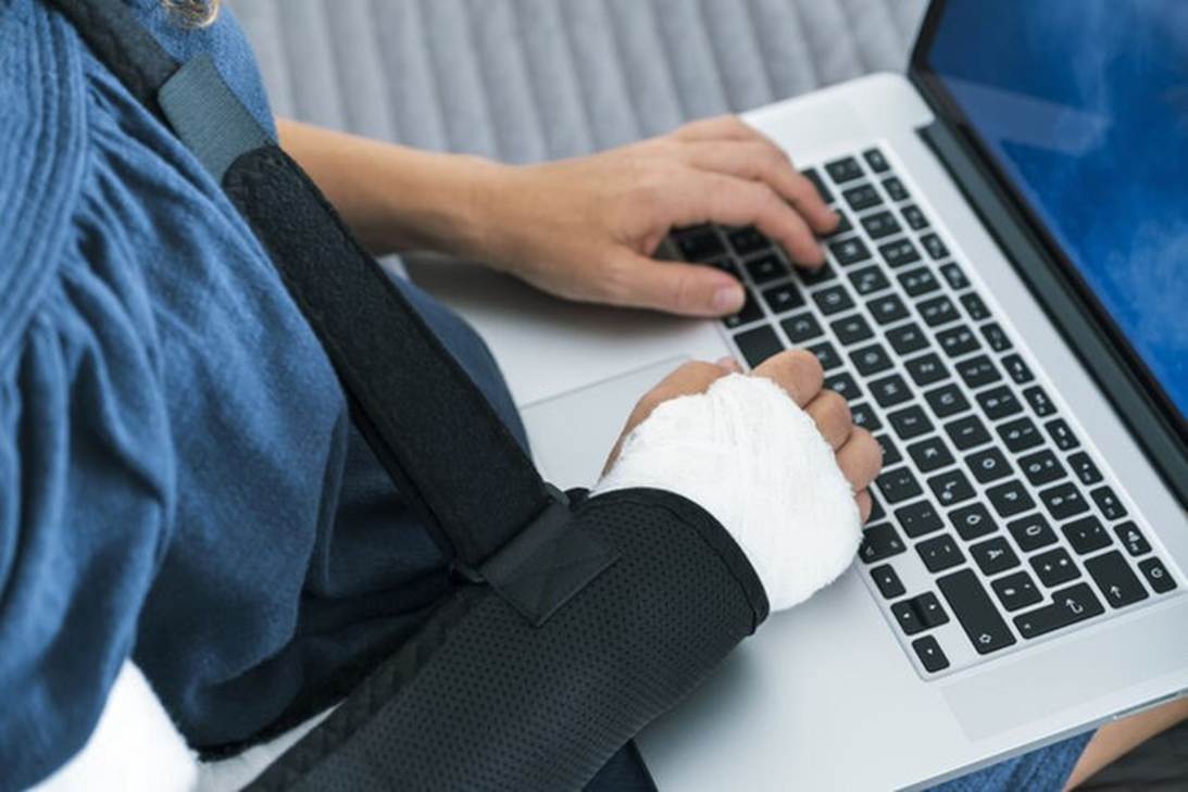 A person with a cast on his arm and a computer
AI-generated content may be incorrect.